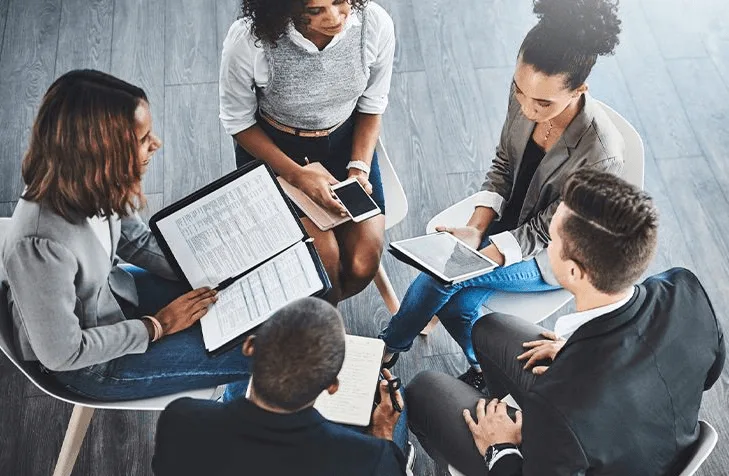 Equipe analisando dados e gráficos sobre uma mesa
